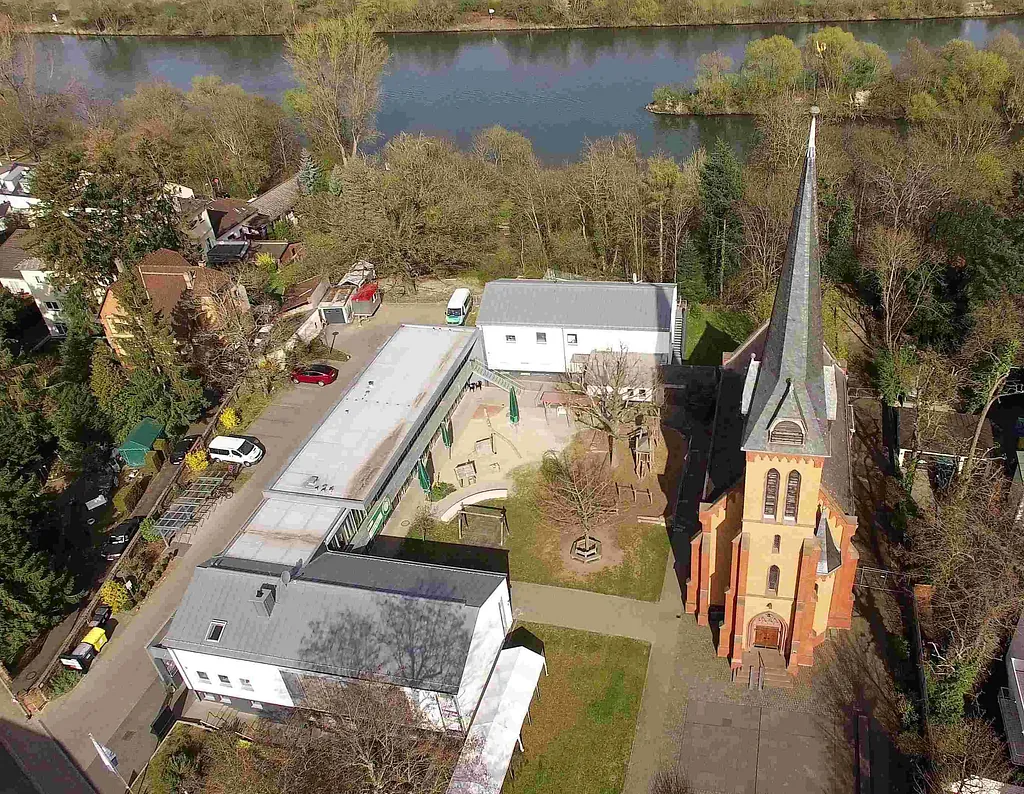 Luftaufnahme der Gebäude: Gemeindezentrum, Kindertagesstätte mit Jugendräumen, Ehemaliges Pfarrhaus wo die Steinheimer Tagespflege und das Zwergennest beheimatet sind.